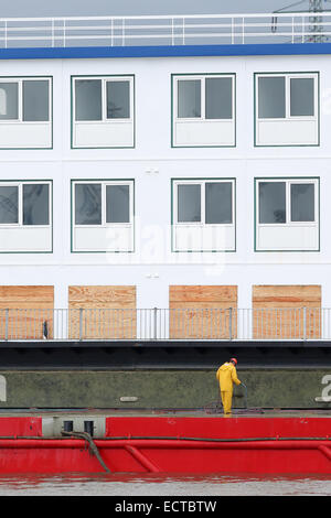 Hambourg, Allemagne. Dec 19, 2014. Le dortoir navire 'transit', l'hébergement de réfugiés à partir de janvier sur, repose sur un ponton à la Trave ports dans le port de Hambourg, Allemagne, 19 décembre 2014. Cet après-midi, le navire est censé être tiré sur le ponton et être portées à son accostage au port intérieur de Hambourg. Le navire pourra accueillir 224 réfugiés à max. PHOTO : BODO MARKS/dpa/Alamy Live News Banque D'Images