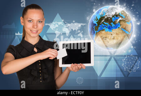 Belle businesswoman holding tablet PC. Globe, carte du monde avec d'autres éléments virtuels en toile Banque D'Images