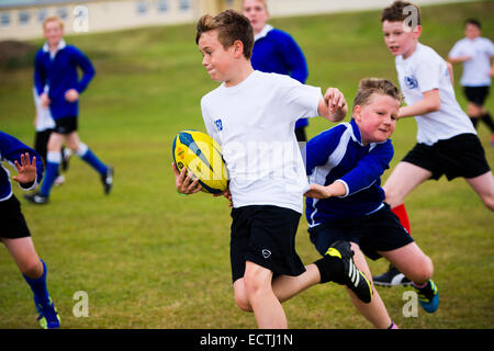 L'école secondaire de l'éducation physique PE - Pays de Galles UK : jeux leçon - les jeunes garçons à jouer au rugby rugger en plein air sur un terrain de sport terrain de pas Banque D'Images
