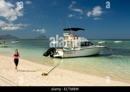 L'Ile Maurice, Flic en Flac, La Pirogue resort beach woman jogging passé Salvo 1 Sport Fishing Boat Banque D'Images