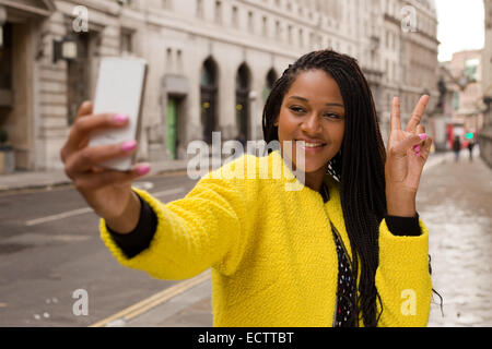 Jeune femme tenant un selfies Banque D'Images