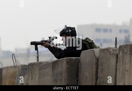 Ramallah, Cisjordanie, territoire palestinien. Dec 19, 2014. Membre de forces de sécurité israéliennes vise son arme au cours d'affrontements à la suite d'une manifestation contre les colonies israéliennes au poste de contrôle de Qalandiya près de la ville de Ramallah, en Cisjordanie, le 19 décembre 2014. Un haut responsable palestinien, Ziad Abu Ein, décédé plus tôt ce mois-ci dans une confrontation avec les troupes israéliennes dans la région de Turmus Aya pendant une marche de protestation contre l'settlementst Muhesen Amren Crédit : Images/APA/ZUMA/Alamy Fil Live News Banque D'Images