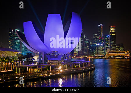 Le Musée ArtScience lumineux violet et skyline avec gratte-ciels et des immeubles de grande hauteur à Singapour de nuit Banque D'Images