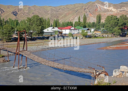 Passerelle sur la primitive ancienne Kurshab river pour atteindre le village rural de Gulcha, la province, le Kirghizistan Banque D'Images