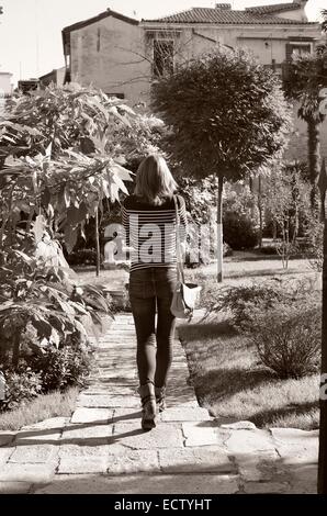 Jeune femme marche dans les jardins Banque D'Images