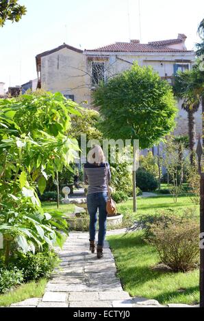 Jeune femme marche dans les jardins Banque D'Images