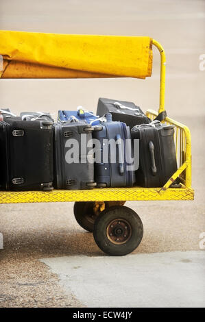 Chariot jaune chargé avec une assurance sur une piste tarmac de l'aéroport Banque D'Images