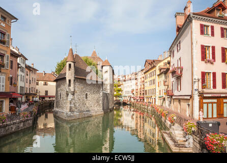 Vieille ville d'Annecy, France. Établissement emblématique Palais de l'Isle château reflète dans la rivière Thiou promenade Riverside, bordée de fleurs colorées Banque D'Images