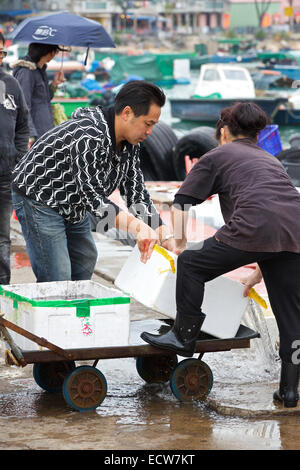 L'homme et de la femme chinoise au marché de poisson de chargement sur Cheung Chau Island, Hong Kong. Banque D'Images