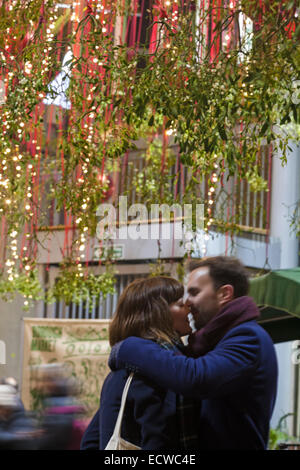 Londres, Royaume-Uni. Dec 19, 2014. Noël au Borough Market, London - couple sous le gui suspendu Crédit : Carolyn Jenkins/Alamy Live News Banque D'Images