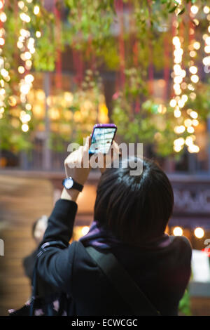 Londres, Royaume-Uni. Dec 19, 2014. Noël au Borough Market, London. Visiteur de prendre une photo de la tenture gui et decorations Crédit : Carolyn Jenkins/Alamy Live News Banque D'Images