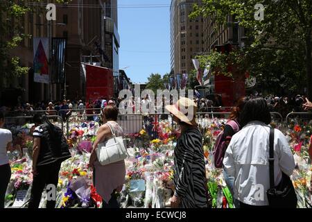 Martin Place, Sydney, Australie. 20 décembre 2014. Les gens regardent les fleurs à gauche pour les deux otages qui sont morts dans le siège au chocolat Lindt Café. Crédit : Copyright 2014 Richard Milnes/Alamy Live News. Banque D'Images