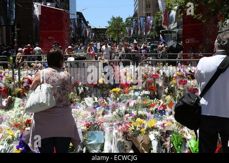 Martin Place, Sydney, Australie. 20 décembre 2014. Les gens regardent les fleurs à gauche pour les deux otages qui sont morts dans le siège au chocolat Lindt Café. Crédit : Copyright 2014 Richard Milnes/Alamy Live News. Banque D'Images