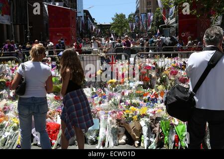 Martin Place, Sydney, Australie. 20 décembre 2014. Les gens regardent les fleurs à gauche pour les deux otages qui sont morts dans le siège au chocolat Lindt Café. Crédit : Copyright 2014 Richard Milnes/Alamy Live News. Banque D'Images