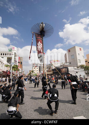 La bannière ( hatagashira / flag ) défiler devant le plus gros remorqueur de la guerre, Kokusai Street, la ville de Naha, Okinawa, Japon Banque D'Images