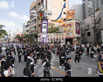 La bannière ( hatagashira / flag ) défiler devant le plus gros remorqueur de la guerre, Kokusai Street, la ville de Naha, Okinawa, Japon Banque D'Images