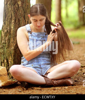 Backwood Hill Billy girl tresser ses cheveux très long, assis sur le plancher 16 Juillet 2014 Banque D'Images