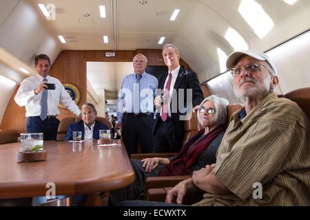 Entrepreneur de l'USAID Alan Gross, emprisonné à Cuba pendant cinq ans, regarde la télévision nouvelle de sa presse, ainsi que de son épouse, Judy, procureur Scott Gilbert, Rép. Chris Van Hollen, le sénateur Patrick Leahy, sénateur et Jeff Flake, à bord d'un avion du gouvernement de retourner à Washington après sa libération le 17 décembre 2014 près de La Havane, Cuba. Banque D'Images