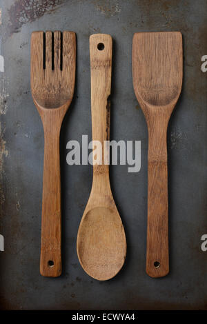 High angle shot de 3 ustensiles de cuisine en bois sur un vieux et bien utilisés. Format vertical. Banque D'Images