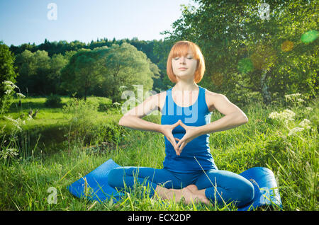 Woman doing yoga asana en plein air dans la nature Banque D'Images