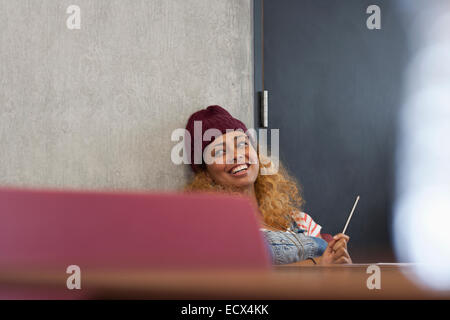 Smiling university student relaxing in classroom Banque D'Images