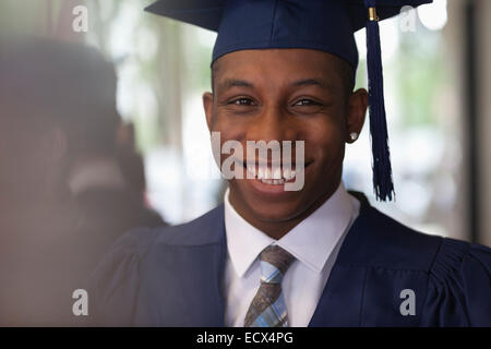 Male student wearing graduation vêtements et smiling at camera Banque D'Images