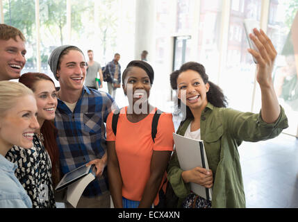 Group of students holding books and digital tablet, en tenant avec selfies smart phone Banque D'Images