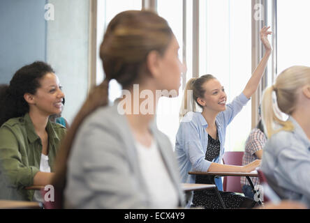 View of smiling female students assis à un bureau dans la salle de classe Banque D'Images