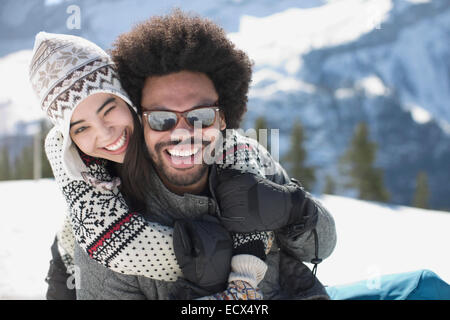 Portrait of happy couple hugging in snow Banque D'Images