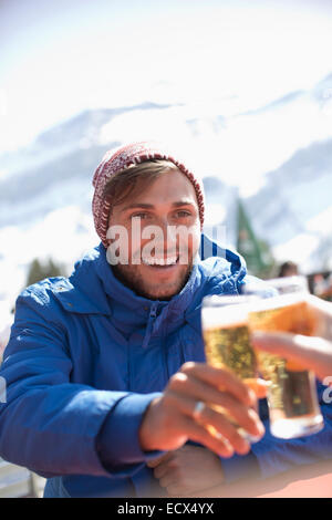 Verres à bière couple toasting outdoors Banque D'Images