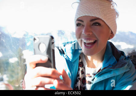 Smiling woman using cell phone Banque D'Images