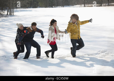 Les amis jouent dans la neige Banque D'Images