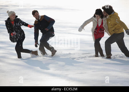 Les amis jouent dans la neige Banque D'Images