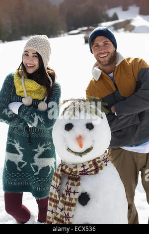 Portrait de couple avec snowman Banque D'Images