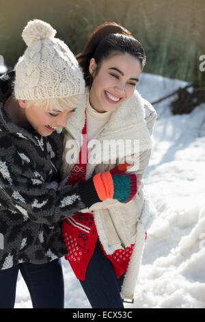 Friends hugging in snow Banque D'Images