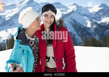 Women hugging and smiling in snow Banque D'Images