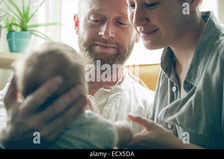 Vue des parents smiling, petit bébé, assise à côté de fenêtre Banque D'Images