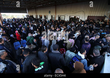 Gaza, la Palestine. Dec 21, 2014. Les Palestiniens, dans l'espoir de pénétrer en Egypte avec sa famille, maintenir leurs passeports et de l'attendre au point de passage de Rafah entre l'Egypte et le sud de la bande de Gaza, le 21 décembre 2014. L'Egypte a rouvert temporairement le poste frontalier de Rafah le dimanche autorisant les Palestiniens de la bande de Gaza d'entrer et sortir pour la première fois depuis qu'il a été fermé le 25 octobre, les fonctionnaires à Gaza a dit. Passage de Rafah Egypte fermée à la suite d'une série d'attaques meurtrières menées par des militants islamistes radicaux dans le Sinaï. Après les attentats, l'armée égyptienne a effectué la plus importante jamais c Banque D'Images