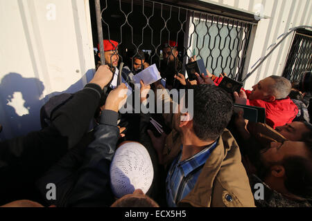 Gaza, la Palestine. Dec 21, 2014. Les Palestiniens, dans l'espoir de pénétrer en Egypte avec sa famille, maintenir leurs passeports et de l'attendre au point de passage de Rafah entre l'Egypte et le sud de la bande de Gaza, le 21 décembre 2014. L'Egypte a rouvert temporairement le poste frontalier de Rafah le dimanche autorisant les Palestiniens de la bande de Gaza d'entrer et sortir pour la première fois depuis qu'il a été fermé le 25 octobre, les fonctionnaires à Gaza a dit. Passage de Rafah Egypte fermée à la suite d'une série d'attaques meurtrières menées par des militants islamistes radicaux dans le Sinaï. Après les attentats, l'armée égyptienne a effectué la plus importante jamais c Banque D'Images