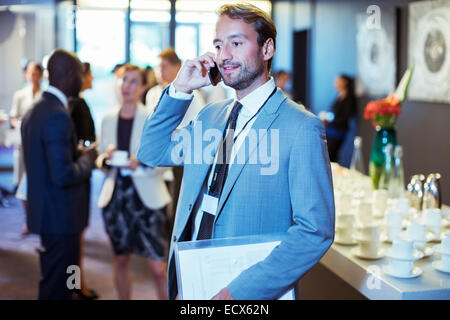 Businessman standing in office document et à l'aide de mobile phone Banque D'Images