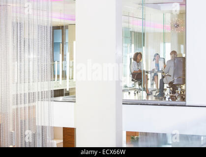 Les gens assis dans la salle de conférence, sourire et parler Banque D'Images