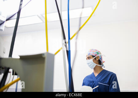 Jeune infirmière le contrôle de l'équipement médical pendant la chirurgie Banque D'Images