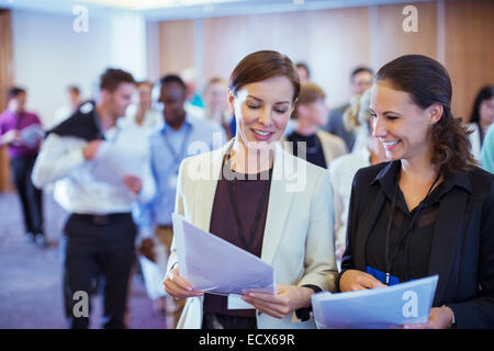 Deux jeunes businesswoman looking through files dans la salle de conférence Banque D'Images