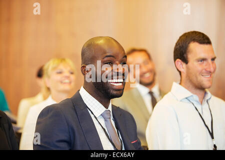 Portrait de deux jeunes hommes, un rire, assis dans la salle de conférence Banque D'Images