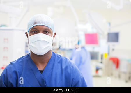 Portrait of surgeon wearing surgical mask et capuchon en théâtre d'exploitation Banque D'Images