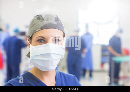 Portrait of female doctor wearing surgical cap et le masque dans le théâtre d'exploitation Banque D'Images