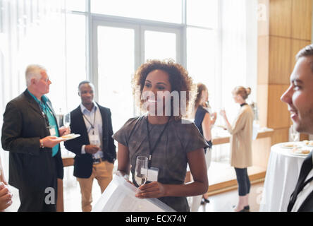 Portrait of young businesswoman standing in hall, avec flûte de champagne dans la main Banque D'Images