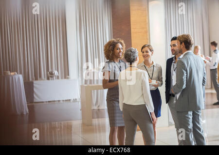 Les gens d'affaires dans la salle de conférence permanent, talking and smiling Banque D'Images