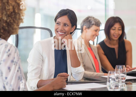 Quatre femmes s'asseoir et parler à table de conférence Banque D'Images