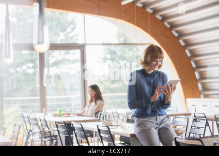 Businesswoman using digital tablet in cafeteria Banque D'Images
